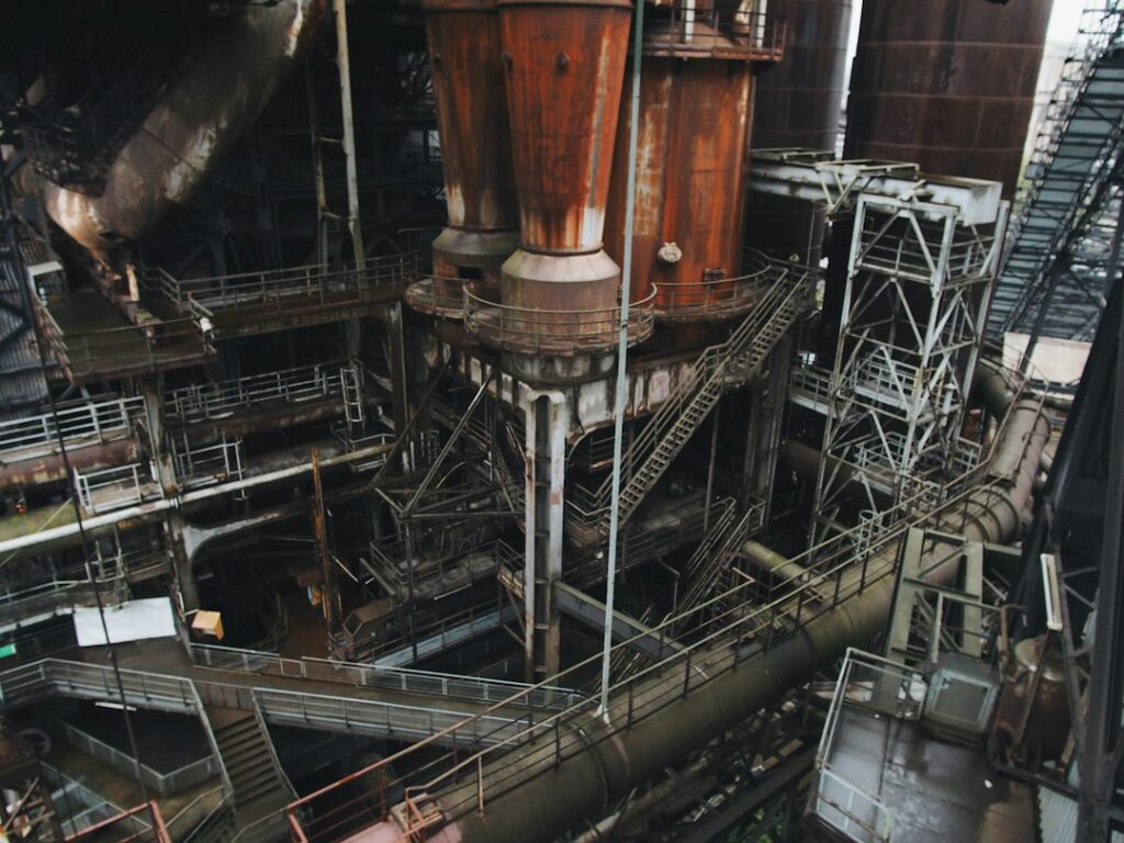 Industrial hopper discharging bulk material while a mounted vibrator operates beside the outlet.
