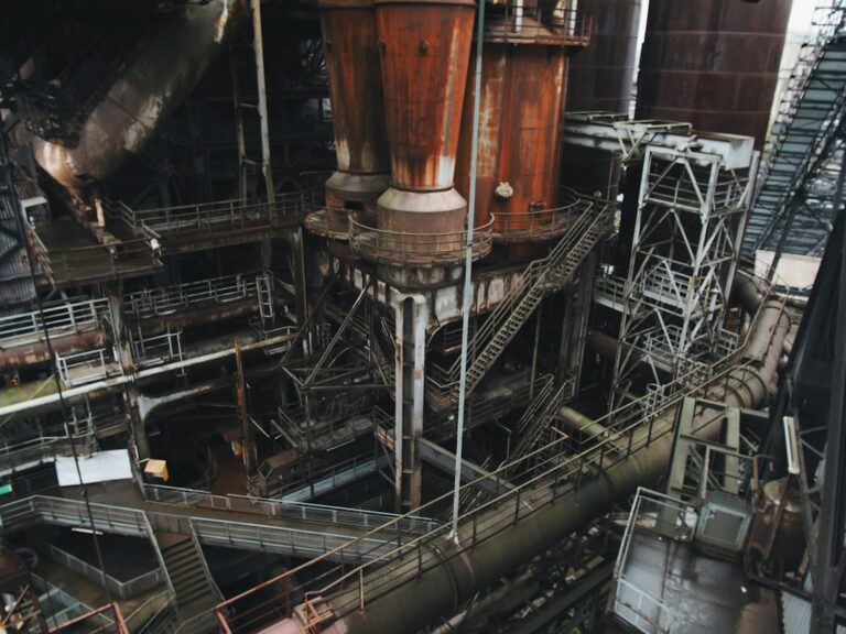 Industrial hopper discharging bulk material while a mounted vibrator operates beside the outlet.