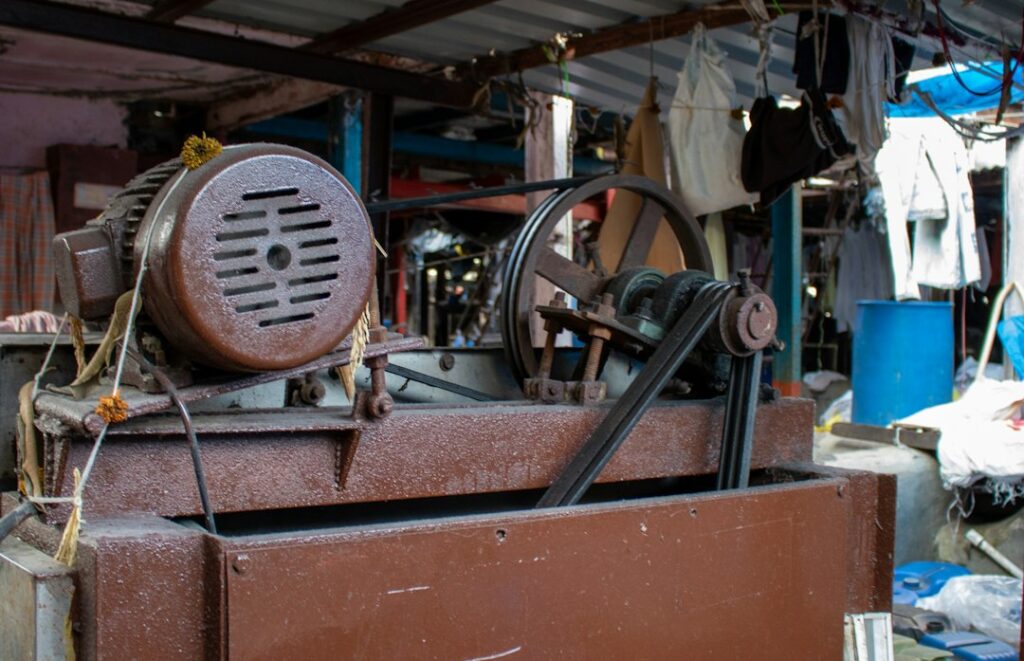 Technician inspecting a vibrating industrial machine with sensors beside a material screening system.