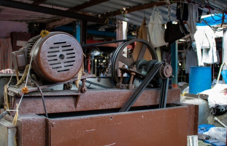 Technician inspecting a vibrating industrial machine with sensors beside a material screening system.